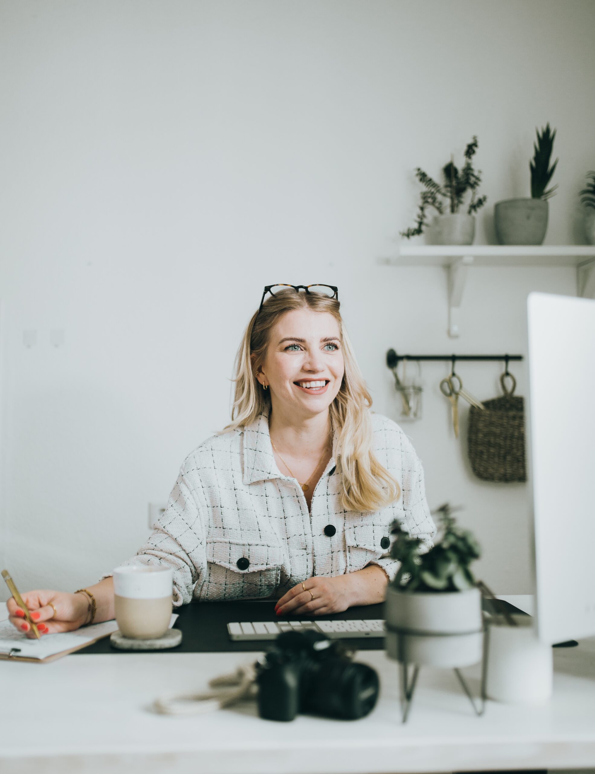 Regina Horn sitzt strahlend am Schreibtisch und plant das nächste Home Staging Projekt